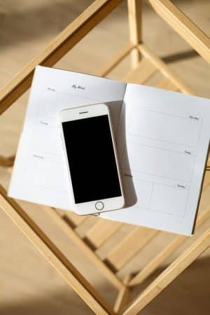 Invitation à prendre rendez-vous : smartphone posé sur un agenda ouvert, pour une séance d'hypnose ou de Reiki avec Béatrice Beilvert
